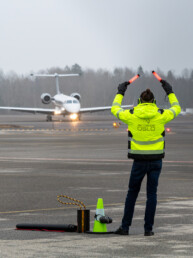 Man with yellow vest is marshaling a private jet at Torp Airport