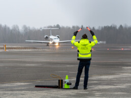 Man with yellow vest is marshaling a private jet at Torp Airport